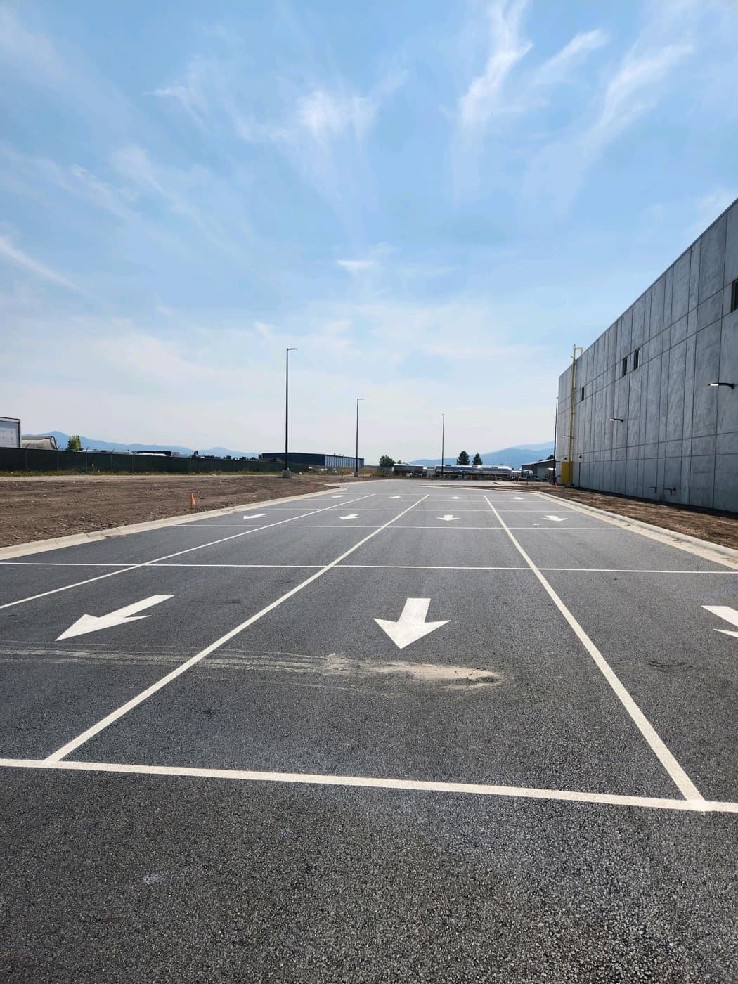 Freshly striped asphalt parking area beside a commercial building